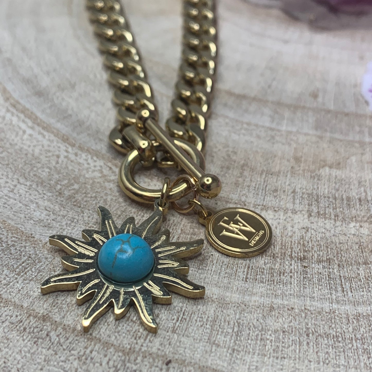 Stainless Chain Linxs with a Sun Shape Pendant and a Turquoise Stone in it.
