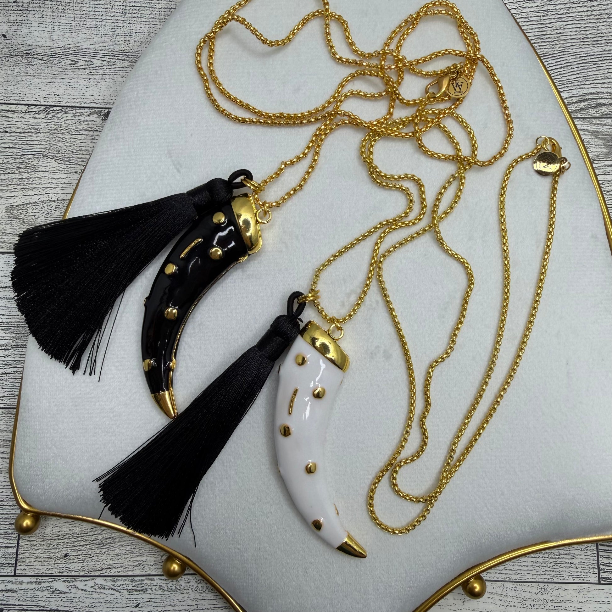 Necklace with black tassels and gold accents on a white plate