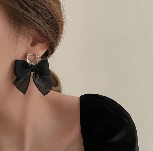 woman wearing bow ribbon black earrings